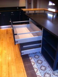 Table et tiroirs ouverts de cuisine menuisée bleue